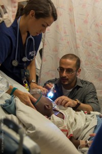 Mercy Ship Volunteers Nurse Amy Humphrey and Dr. Mark Shrime examine Emmanoel after surgery to remove a tumor from his throat. Photo credit: ©Mercy Ships / Josh Callow 